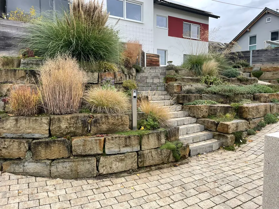 Terrassierter Hang mit Natursteinmauern und Treppe